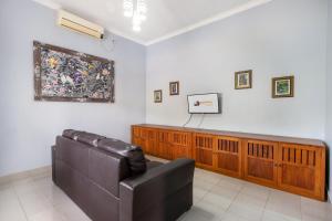 a court room with a leather couch and a television at Bon Nyuh Bungalows in Gianyar