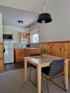 a kitchen with a wooden table and chairs at D'Altons Studios in Halls Gap
