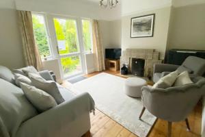 a living room with a couch and chairs and a fireplace at Meadowside Troutbeck Bridge, Windermere sleeps 5-6 in Windermere