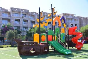 un parque infantil con un tobogán frente a un edificio en Andriake Beach Club Hotel, en Demre