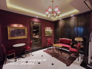 a room with red chairs and a table and a chandelier at Double Bed Hotel in Bangkok