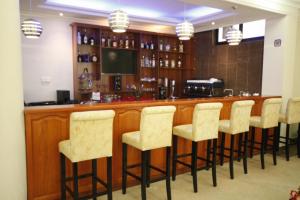 a bar with a row of stools in a room at caravan Hotel Addis in Addis Ababa