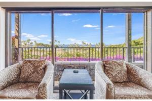 2 chaises et une table devant une grande fenêtre dans l'établissement WAILEA ELUA, #0105 condo, à Wailea 35 autres photos