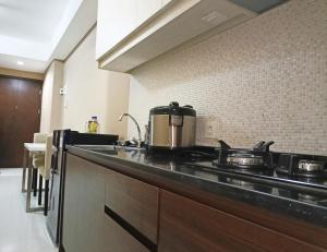 a kitchen with a stove and a counter top at Apartement Borneo Bay Tower kartanegara Balikpapan in Balikpapan