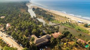 an aerial view of a beach with a river and palm trees at Riva Beach Resort in Mandrem