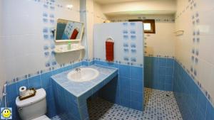 ein blau-weißes Bad mit einem Waschbecken und einem WC in der Unterkunft Smile House & Pool in Rawai Beach