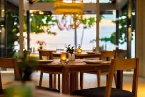 a wooden table in a restaurant with candles on it at Outrigger Khao Lak Beach Resort - SHA Extra Plus in Khao Lak