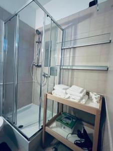 baño con ducha y estante con toallas en Appartamento tra Aeroporto DaVinci e Fiera di Roma, en Fiumicino