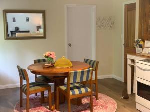 a kitchen with a wooden table with chairs and a mirror at Cloudland Garden Oasis in Blackheath