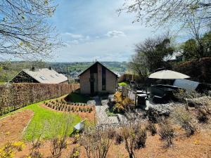 un jardín con una casa pequeña y una sombrilla en Livremont7 en Malmedy