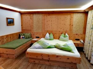 two beds in a room with wooden paneling at Haus Waldesruh in Neustift im Stubaital