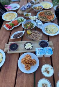 una mesa de madera con platos de comida. en צימר מעל העננים en Ein Kinya