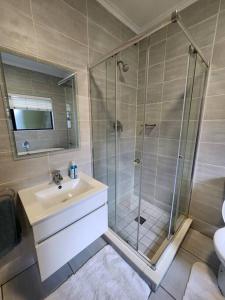 a bathroom with a shower and a sink and a toilet at Modern 3-bed Garden Apartment in Waterfall in Midrand