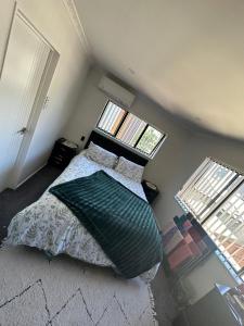 a small bedroom with a bed and two windows at Auckand Holiday in the Golden Circle in Auckland
