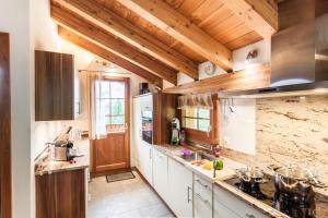 a large kitchen with wooden ceilings and wooden counters at Chalet Hinter Dem Rot Stei in Zermatt