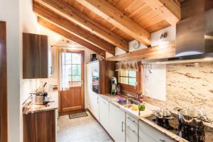 une grande cuisine avec des plafonds en bois et des comptoirs en bois dans l'établissement Chalet Hinter Dem Rot Stei, à Zermatt