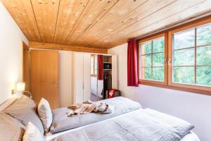 a bedroom with a bed and a wooden ceiling at Chalet Hinter Dem Rot Stei in Zermatt