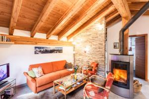 un salon avec un canapé et une cheminée dans l'établissement Chalet Hinter Dem Rot Stei, à Zermatt