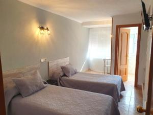 una habitación de hotel con 2 camas en una habitación en Hostal Fronton, en Alcobendas