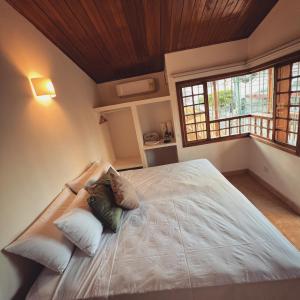 una camera da letto con un grande letto con cuscini sopra di Hostal Magdalena a Santa Marta