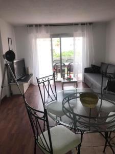 salon ze szklanym stołem i krzesłami w obiekcie Appartement en front de mer avec parking privatif w Fréjus