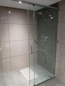 a shower with a glass door in a bathroom at Anukulas Residency - Vellore in Vellore