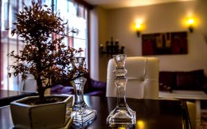 a table with two glass vases and a plant on it at Hotel MINOS in Preveza