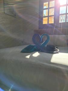 una cinta azul en forma de corazón en una cama en Villa RENE, en Saint-Génis