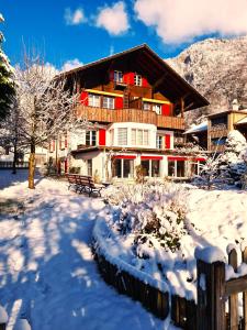 una casa en la nieve con una valla en Adventure Guesthouse Interlaken en Interlaken