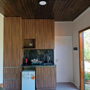 eine Küche mit einem weißen Kühlschrank und Holzschränken in der Unterkunft La Canaria Casa de Campo in Colonia Caroya