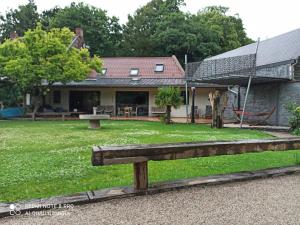a wooden bench sitting in front of a house at Le clos marin in Blendecques