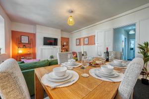 a dining room with a wooden table and chairs at Brewery Loft - 3 Bedroom Bright Spacious apartment in the centre of town, Wifi, Netflix in Cirencester