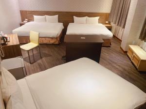 Pokój hotelowy z 2 łóżkami i krzesłem w obiekcie Zhongshan Boutique Hotel w mieście Kaohsiung