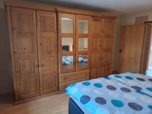 a bedroom with wooden cabinets and a bed at Ferienwohnung Schleiten 2 in Püttlingen