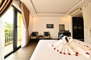 Postel nebo postele na pokoji v ubytování Hoi An Rose Garden Hotel