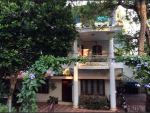 Casa blanca con balcón y árboles en Veda Wellness B&B and Yoga Centre, en Kochi