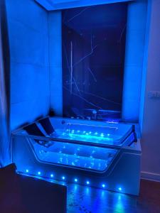 a blue bathroom with a tub with blue lights at Apartament z jacuzzi in Kraków