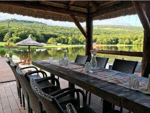 een houten tafel met stoelen en uitzicht op een meer bij Wellness Hotel Vinnay in Vinné