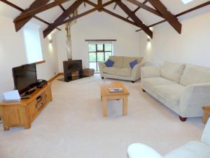 a living room with two couches and a tv at Great Barns in South Pool