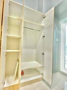 a white closet with white shelves and a window at Room 35 in Manila