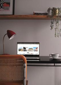 einen Laptop auf einem Schreibtisch mit einer Lampe in der Unterkunft Art & Pleasure WAW z bezpłatnym parkingiem in Warschau