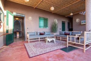 馬拉喀什的住宿－La ferme，庭院设有蓝色的沙发和地毯上的桌子。