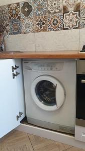 uma máquina de lavar roupa numa cozinha debaixo de um balcão em 1-комнатная квартира em Kokshetau