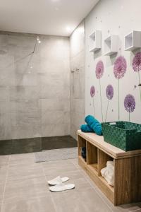 La salle de bains est pourvue d'une douche avec des fleurs violettes sur le mur. dans l'établissement L'alcôve du 510 - Spa - chambre romantique - sauna - salle de jeux, à Montauban