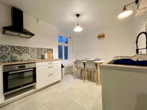 a kitchen with a sink and a table with chairs at Appartement confort - Carcassonne centre - NETFLIX in Carcassonne +9 photos