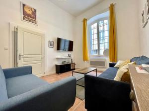 a living room with two blue couches and a tv at Appartement confort - Carcassonne centre - NETFLIX in Carcassonne