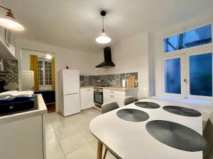 a kitchen with a white table and a white refrigerator at Appartement confort - Carcassonne centre - NETFLIX in Carcassonne