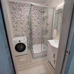 a bathroom with a shower and a washing machine at Apartament lux new in Chişinău