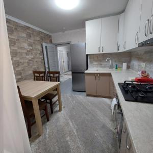 a kitchen with a wooden table and a kitchen with white cabinets at Apartament lux new in Chişinău
