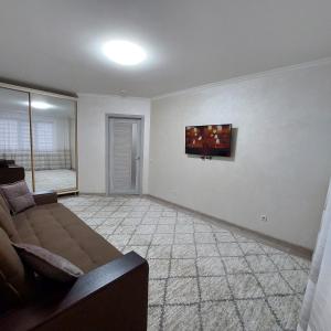 a living room with a couch and a tv on the wall at Apartament lux new in Chişinău